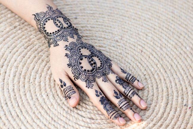 Clasped hands with brown henna design