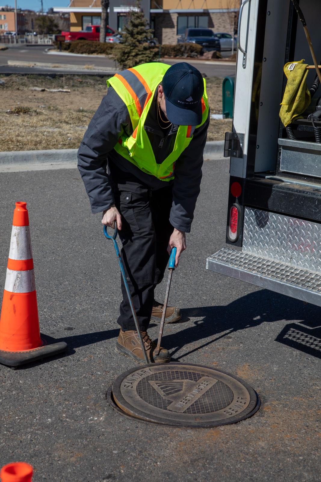 Wastewater Crewman Removing a Manhole Cover